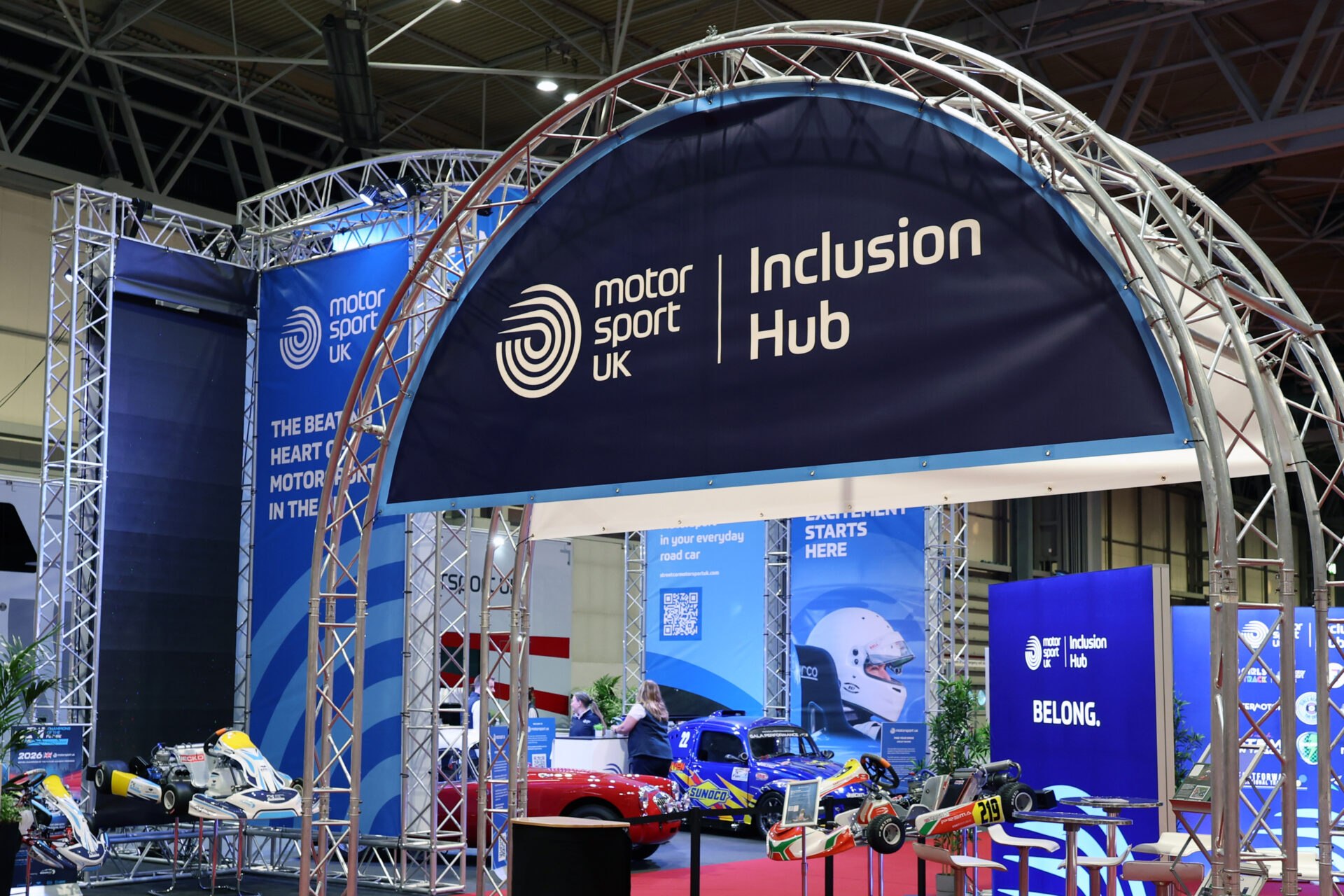 Blue arched sign features the Motorsport UK logo and reads 'inclusion hub'.