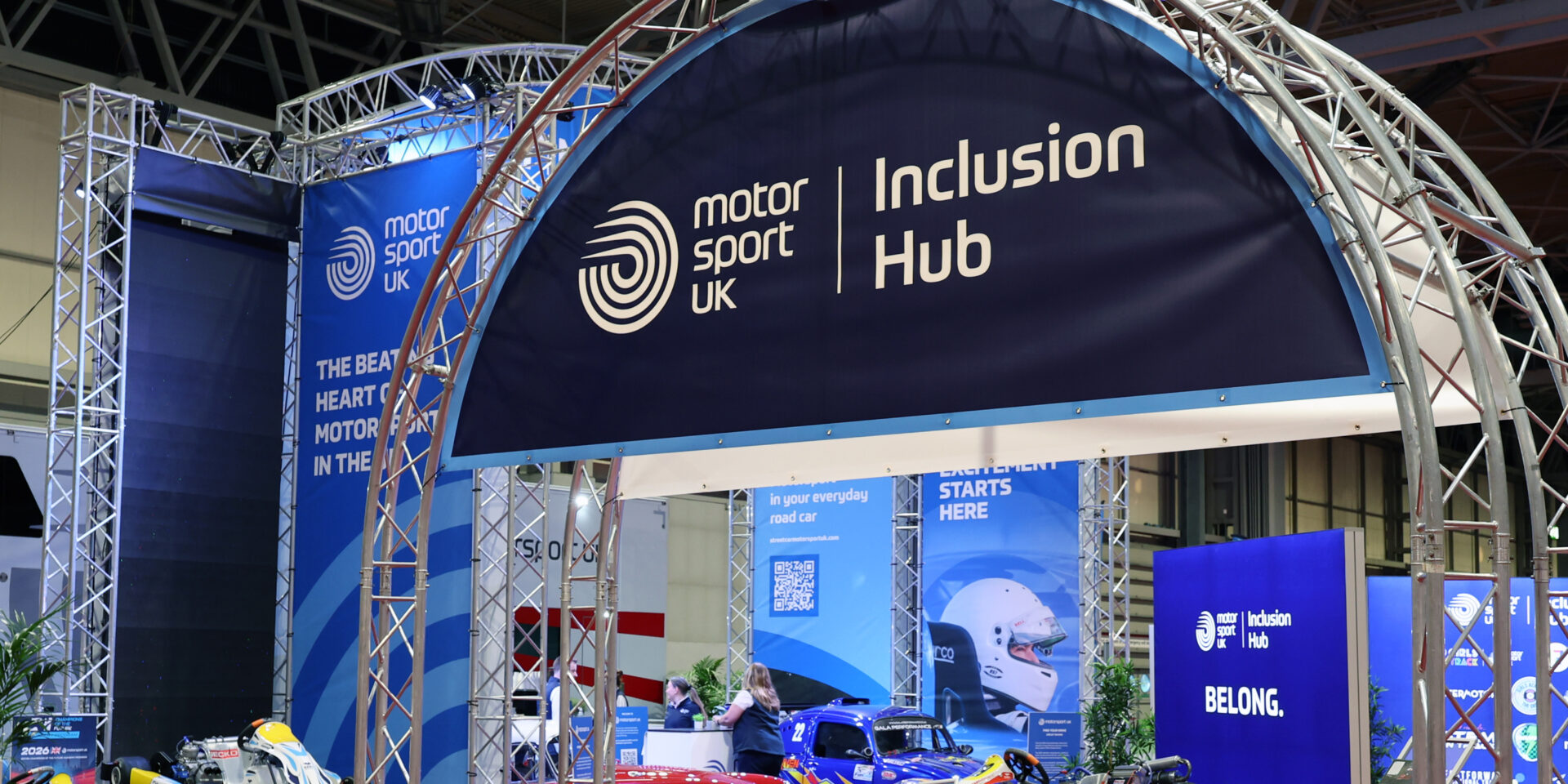 Blue arched sign features the Motorsport UK logo and reads 'inclusion hub'.