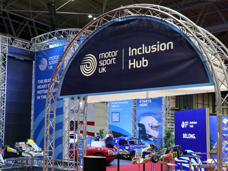 Blue arched sign features the Motorsport UK logo and reads 'inclusion hub'.